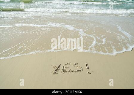 JA, Konzept, Wort geschrieben auf Sandstrand Stockfoto