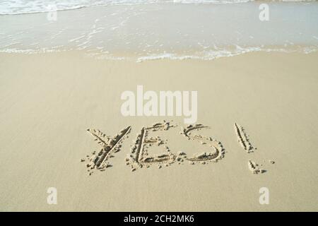 JA, Konzept, Wort geschrieben auf Sandstrand Stockfoto