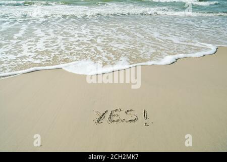 JA, Konzept, Wort geschrieben auf Sandstrand Stockfoto