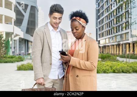 Junge afrikanische Geschäftsfrau, die Online-Nachrichten von Kollegen oder neugierige Werbung zeigt Stockfoto