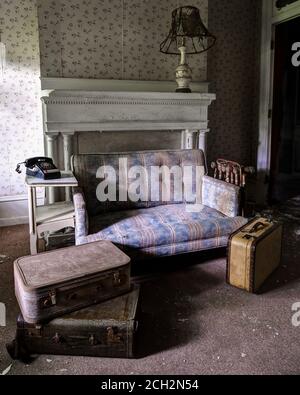 Verlassenes Haus mit Sofas und Koffern Stockfoto