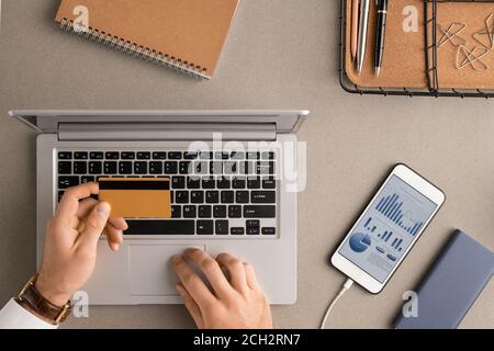 Überblick über die Hände eines jungen modernen Geschäftsmannes mit Kreditkarte Stockfoto