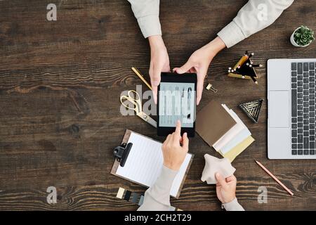 Flatlay der Hände kreativen Designer zeigt auf Skizzen auf dem Display Des Tablets Stockfoto