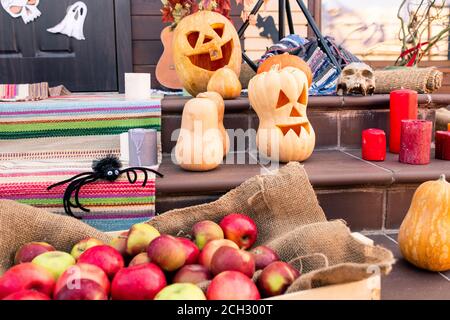 Gruppe von reifen halloween Kürbisse, Spinne, Haufen von Äpfeln, Schädel, rote Kerzen Stockfoto