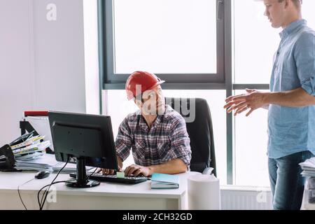Qualifizierte Techniker ist im Gespräch mit Kollegen bei der Arbeit. Informatik-Konzept Stockfoto