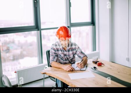Fleißige Männer Ingenieur im Büro, ist er trägt ein weißes Hemd und  Krawatte, Laptop, Bindemittel und weißen Schutzhelm auf dem Tisch  Stockfotografie - Alamy