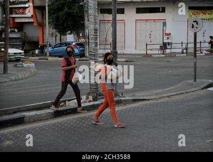 Gaza. September 2020. Palästinensische Mädchen mit Gesichtsmasken gehen am 13. September 2020 auf einer Straße in Gaza-Stadt. Palästina meldete am Sonntag 994 neue COVID-19 Fälle in den palästinensischen Gebieten, was die Gesamtzahl auf 39,510 erhöht. Kredit: Rizek Abdeljawad/Xinhua/Alamy Live Nachrichten Stockfoto