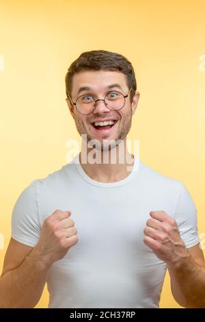 Ein verrückter Mann mit großen Augen und geballten Fäusten.viel Spaß. Narr Kerl in Brille. Clown-Konzept. Stockfoto