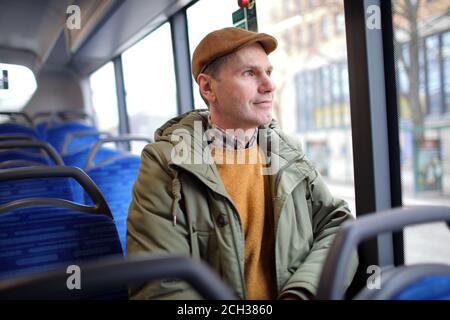 Reifer kaukasischer Mann sitzt in einem öffentlichen Bus Stockfoto