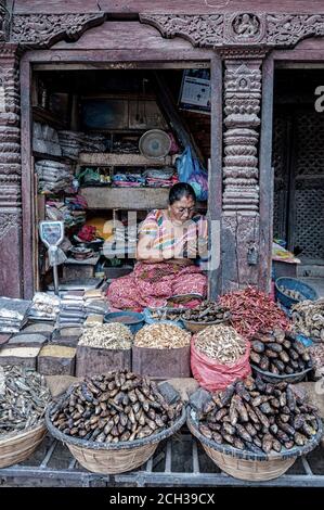 KATHMANDU, NEPAL - 14. AUGUST 2018: Eine nicht identifizierte nepalesische Frau sitzt in der Straße von Kathmandu, Nepal Stockfoto