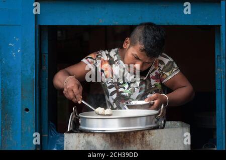 KATHMANDU, NEPAL - 14. AUGUST 2018: Nicht identifizierter nepalesischer Mann, der in seinem Laden in der Straße von Kathmandu, Nepal, Momos kocht Stockfoto