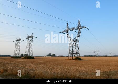 Gruppe von elektrischen Pylonen, Hochspannungsleitungen. Deckenkabel, die Strom in die Städte transportieren. Stockfoto