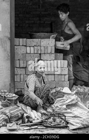 KATHMANDU, NEPAL - 14. AUGUST 2018: Nicht identifizierte nepalesische Frau sitzt in der Straße von Kathmandu Stockfoto