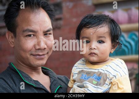 KATHMANDU, NEPAL - 14. AUGUST 2018: Nicht identifizierter nepalesischer Mann mit seinem kleinen Kind in der Straße von Kathmandu, Nepal Stockfoto