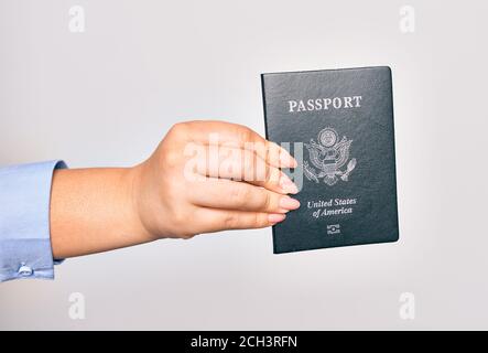 Hand der kaukasischen jungen Frau, die ein passdokument der vereinigten Staaten auf isoliertem weißem Hintergrund hält Stockfoto