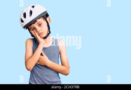 Kleine niedliche Junge Kind trägt Fahrrad Helm Denken suchen müde und gelangweilt mit Depressionen Probleme mit gekreuzten Armen. Stockfoto