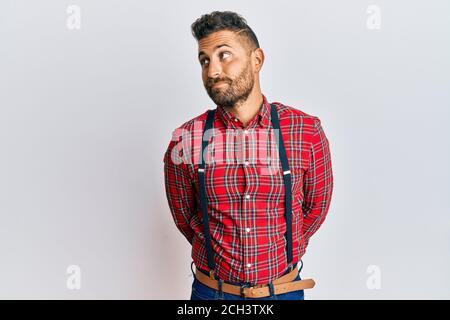 Schöner Mann mit Bart trägt Hipster eleganten Look lächelnd Blick zur Seite und starrte weg denken. Stockfoto