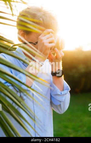 Junge Fotografin, die mit einer Kamera fotografiert Stockfoto