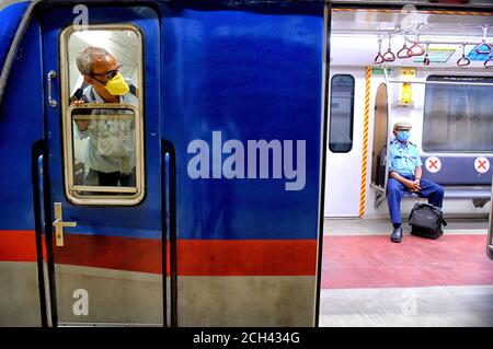 Ein Metro-Bahnfahrer mit Gesichtsmaske sieht die Fahrgastbewegung aus seiner Kabine aus.Kolkata Metro hat ihren Betrieb nach 170 Tagen wegen Covid 19 Pandemie wieder aufgenommen und wird ab morgen phasenweise betrieben. Stockfoto
