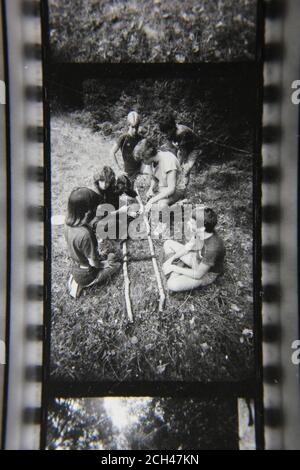 Feine 70er Jahre Vintage Schwarz-Weiß-Fotografie von Pfadfindern Training für erste Hilfe beim Camping im Pfadfindercamp. Stockfoto