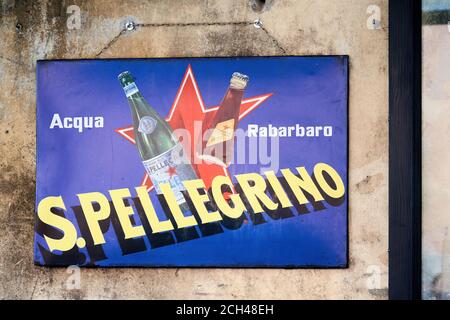 Acqua San Pellegrino Schild. Authentisches Vintage-Zeichen des berühmten italienischen Mineralwasser auf dem Ombre Rosse Restaurant Eingang in Piazza S.Egidio platziert Stockfoto