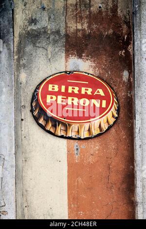 Birra Peroni Handelszeichen. Authentisches, Vintage Oval Zeichen des berühmten italienischen Bieres auf einer Peeling Wand eines Restaurants platziert Stockfoto