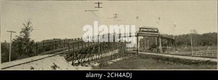 . Die Straßenbahnbesprechung . ne Meilen entfernt, in Richtung oi Lewistor..llie zweite bei Lewiston, 19 Meilen entfernt, und die dritte bei Bath.an den Transformatorstationen wird der Strom auf 330 Volt abgesetzt, abwechselnd durch stationäre Transformatoren, Dann in Drehumrichter, die ihn in einen 550-Volt-Gleichstrom für die Obleyline umwandeln. Das Umspannwerk am zweiten Teil der Linie ist ein kleines Ziegelgebäude, das in der Nähe einer der großen Autohäuser steht, von denen es drei gibt, eine für jede der drei Divisionen. Die Kondensatoren, die mit den Motoren in dieser Station verwendet werden, sind f Stockfoto
