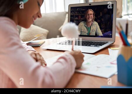 Online-Lehrer auf Laptop-Bildschirm geben Remote-Zoom-Klasse für Schulmädchen. Stockfoto