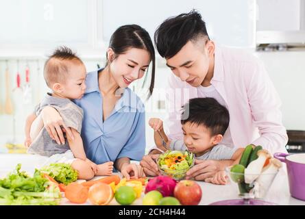 Glückliche Familie bereitet Abendessen mit gesunden Lebensmitteln in der Küche Stockfoto