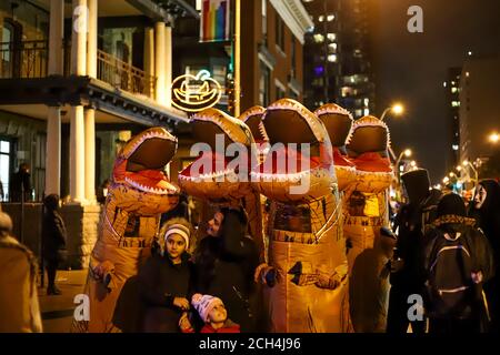 Halloween Nacht Karneval . Kirche Straße, Menschen zu Fuß in verschiedenen Masken und Kostümen. Stockfoto