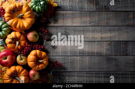 Herbsthintergrund Dekor aus Kürbissen, Beeren, roten Äpfeln und Blättern auf dunklem Holzhintergrund. Flach liegend, Draufsicht mit Kopierplatz für Herbst, Herbst, Stockfoto
