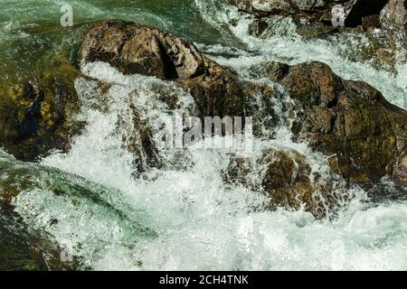 Wasser spritzt über Felsen Stockfoto