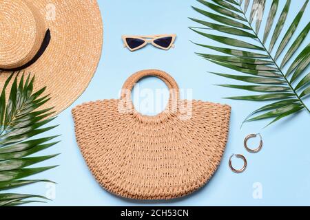 Weidensack mit Hut und weiblichen Accessoires auf farbigem Hintergrund Stockfoto