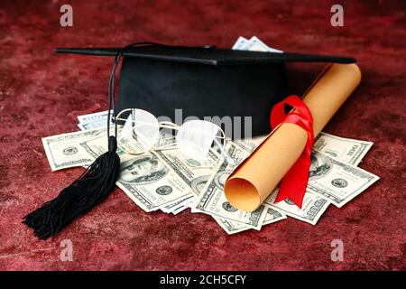 Abschlusshut, Diplom und Geld auf grunge Hintergrund. Studiengebühren Konzept Stockfoto