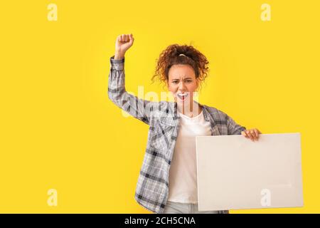 Wütend protestierende afroamerikanische Frau mit Plakat auf farbigem Hintergrund Stockfoto