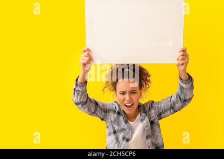 Wütend protestierende afroamerikanische Frau mit Plakat auf farbigem Hintergrund Stockfoto