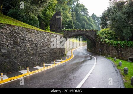Eine kurvenreiche Straße führt zu einer kleinen Stadt am Comer See in Norditalien. Stockfoto
