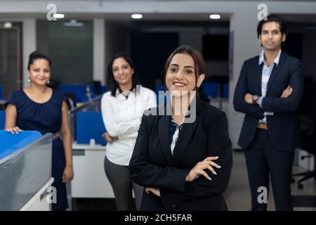 Selbstbewusste indische Geschäftsfrau, die vor ihren Bürokollegen steht, selektiver Fokus, Unternehmensumfeld, Teammitglieder, Geschäftsbüro. Stockfoto