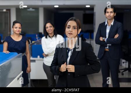 Selbstbewusste indische Geschäftsfrau, die vor ihren Bürokollegen steht, selektiver Fokus, Unternehmensumfeld, Teammitglieder, Geschäftsbüro. Stockfoto