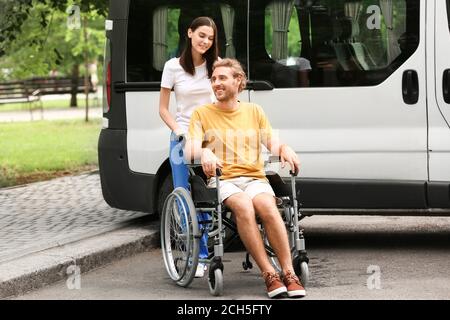 Junge Frau mit ihrem behinderten Mann in der Nähe von Auto im Freien Stockfoto