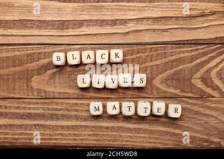 Würfel mit Text SCHWARZ LEBT MATERIE auf Holzgrund Stockfoto