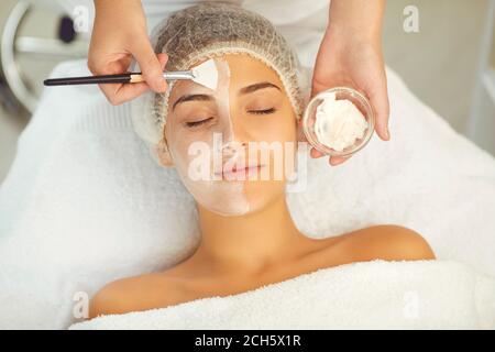 Dermatologe Putting feuchtigkeitsspendende Maske, um Frauen Gesicht während der Hautpflege Verfahren Stockfoto