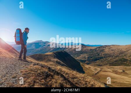 Wanderer auf der Bergspitze genießt die Aussicht. Fernweh und Reisekonzept Stockfoto