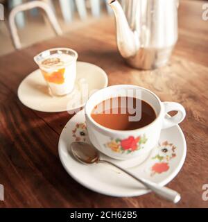 Entspannen Sie sich in einem alten Café am frühen Morgen, vintage eine Tasse Kaffee mit weich gekochtem Ei und Teekessel sind auf alten Holztisch. Stockfoto