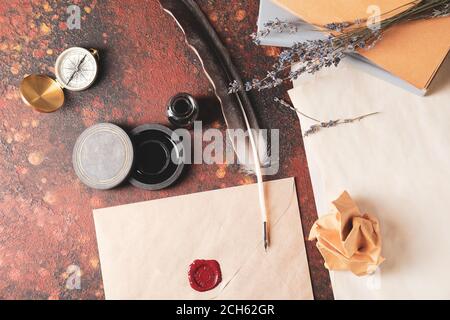 Federstift mit Umschlag und Tinte auf farbigem Hintergrund Stockfoto