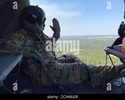 US Army Staff Sgt. Kevin Schrecengost, Crewchef bei Alpha Company, 2-104th General Support Aviation Bataillon, 28th Expeditionary Combat Aviation Brigade posiert für ein Foto während der Fahrt in einem UH-60 Black Hawk Hubschrauber während einer Brandbekämpfung Mission an der 28th ECAB Mobilisierungsstation. (USA Armee Foto von 1. Sgt. Matthew Stohrer) Stockfoto