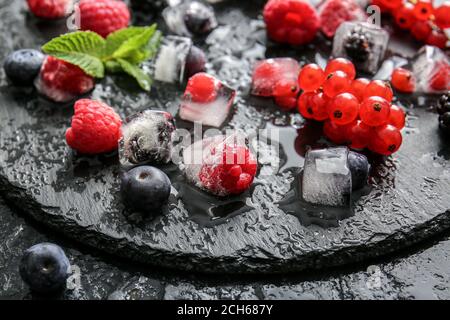 Eis mit gefrorenen Beeren auf dunklem Hintergrund Stockfoto