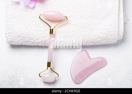 Gua Sha Massagegerät und Gesichtswalze auf Stein Hintergrund. Anti-Age-, Hebe- und Tonungsbehandlung - Bild Stockfoto