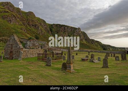 Die Nether Kirkyard Begräbnisstätte am Fuße der dramatischen Klippen im St Cyrus National Nature Reserve, mit seinen alten Grabsteinen und Begräbnis enc Stockfoto