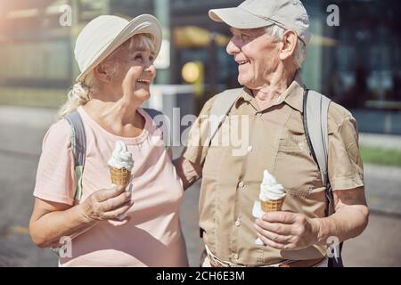 Ältere Menschen mit Rucksäcken lächeln sich an Stockfoto